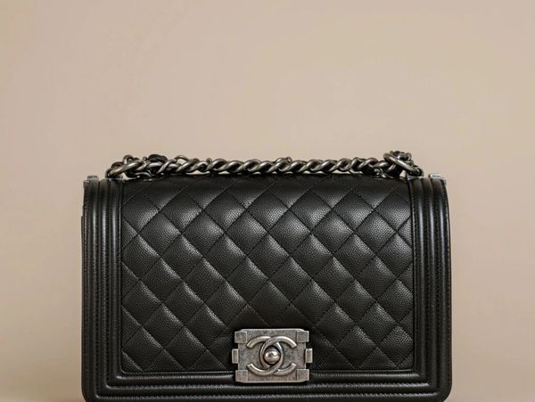 Elegant black quilted leather handbag with silver chain and clasp.