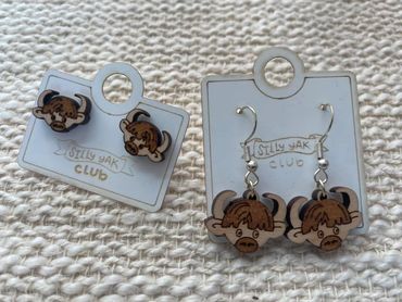 Wooden yak-themed earrings on Silly Yak Club cards.