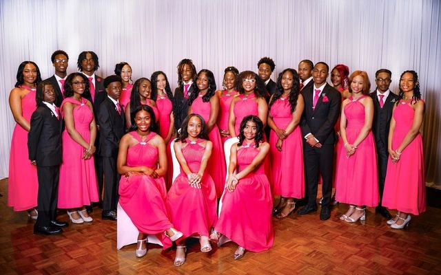 Group dressed in formal wear with pink dresses and suits.