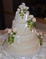 4 tier wedding fondant wedding cake with handmade sugar ivory roses and edible pearls.