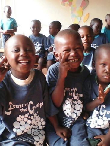 Happy children in matching shirts at a classroom.