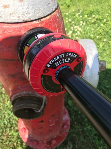 Hydrant Drain Meter HYD-10 attached to front of hydrant above port cap.