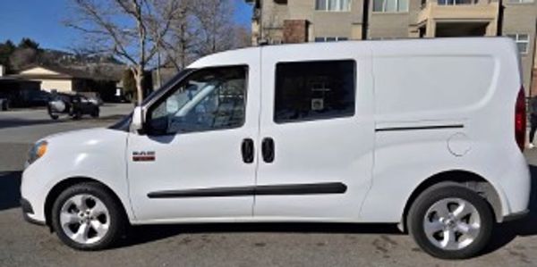 White cargo van parked on a residential street in daylight.