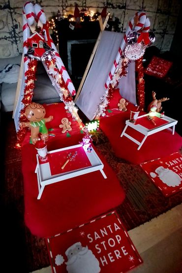 Cozy Christmas-themed indoor setup with festive tents and decorations.