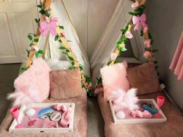 Two cozy pink seating areas with trays of spa items.
