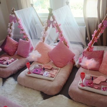Cozy pink-themed sleepover setup with cushions and trays.