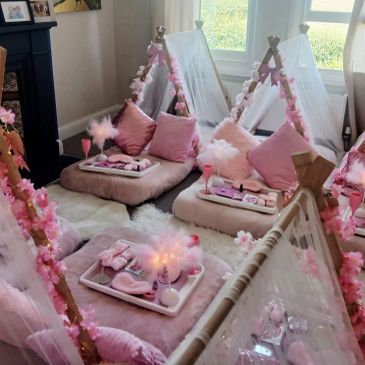 Pink-themed indoor sleepover setup with mini tents.