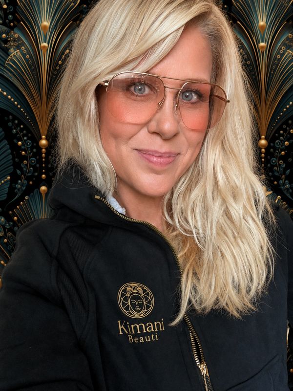 Blonde woman with pink-tinted sunglasses and Kimani Beauti jacket.