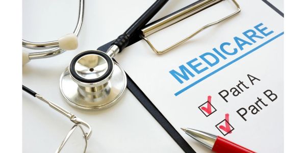Medicare form with Part A and B checked beside a stethoscope and pen.