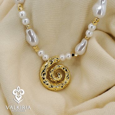 Elegant pearl necklace with a gold spiral pendant on beige fabric.