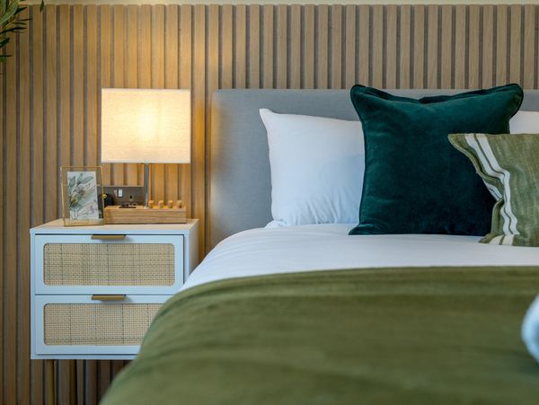Cozy bedroom corner with bed and bedside table.