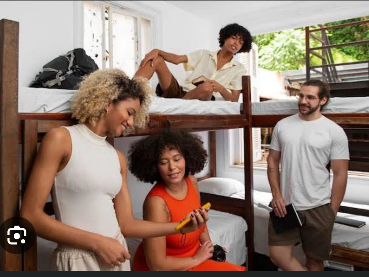 two women are seen on the phone and two men are seen watching them.