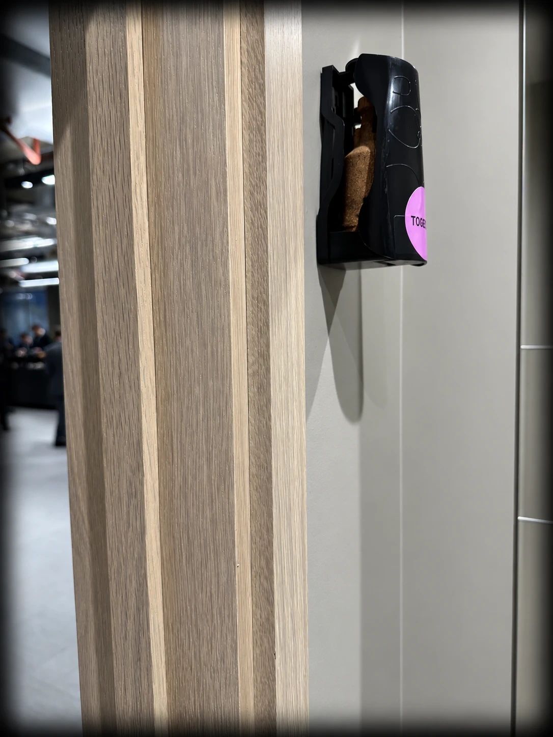 Side view of an Ethicork™ refill inside a black wall-mounted dispenser in a TOGETHER.SPACE washroom