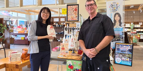 Two people standing in a store holding products.
