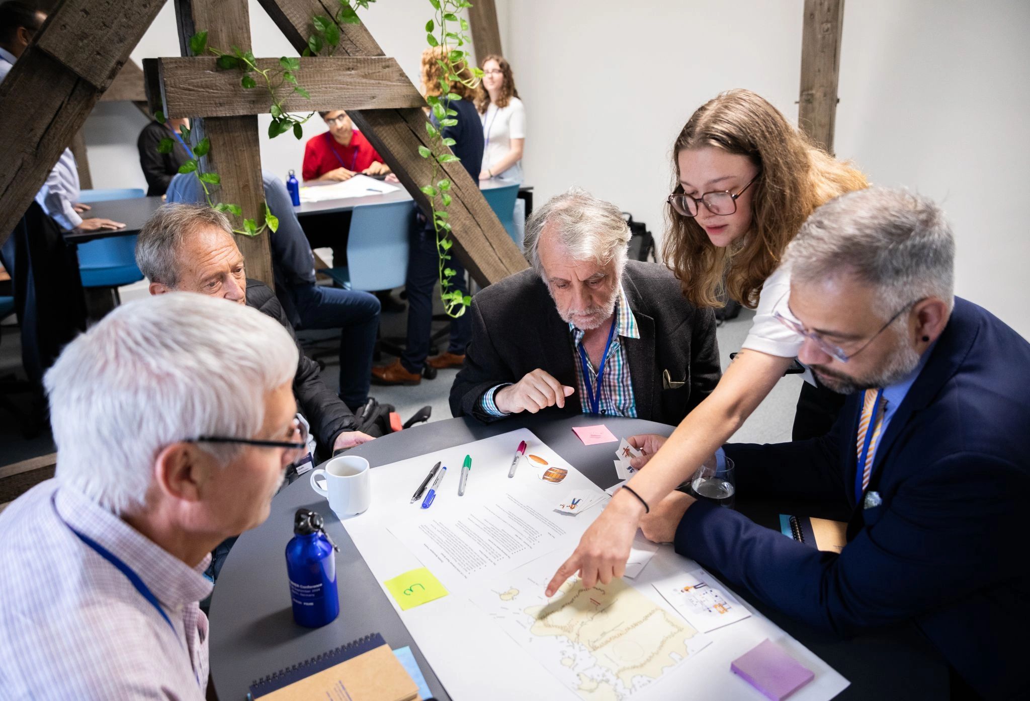 Frankie Pellitier, 2024 Wicked Society member explaining map, and resources at a workshop in Berlin.