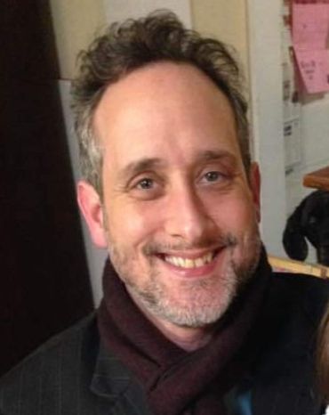 Ryan Walther. A mid-aged white man with short dark hair, short salt and pepper beard, and a maroon s