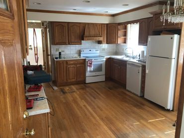 Spacious kitchen with wooden cabinets and hardwood floors.