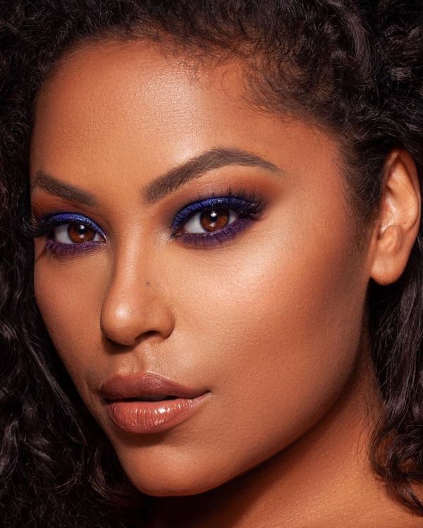 purple eyeliner on top and bottom of eyes on female african american model