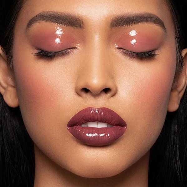 pink glossy eyelids, berry pink lipstick, and soft pink blush on female model with medium brown skin