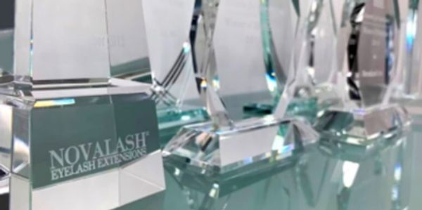 a shelf full of several glass awards earned by novalash