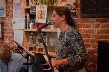 Lucy Gove leads the singing at Chatterbox Cafe, Canterbury.