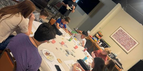 Group of people sitting around a table during a meal or activity.