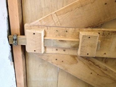 Close-up of a wooden door latch mechanism.