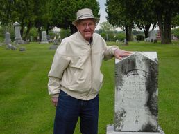 Russell Grinolds with the gravemarker of his great-grandfather, John M. Grinolds in Mauston, WI