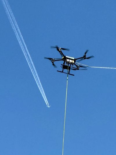 Low-angle cleaning drone in operation by FlyWash Drone operator