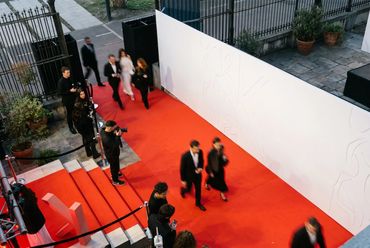 Ingreso con alfombra roja a un evento de marca por la noche