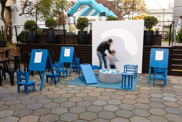 Espacio de actividades para chicos con atriles y sillas azules en un evento