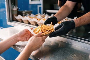 Foodtruck sirviendo papas fritas durante un evento