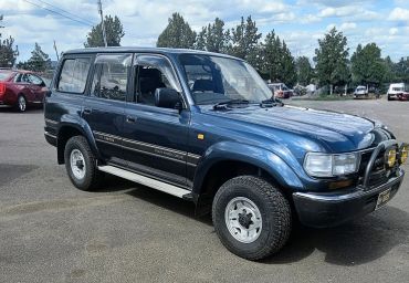 Blue Toyota Land Cruiser 4WD jdm rhd parked outdoors on a sunny day.