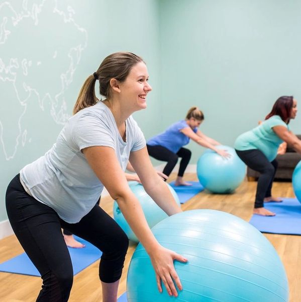 Pregnant women in a blue room with blue birthing balls