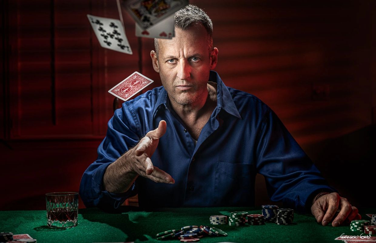 Jim Inch at poker table. Throws cards at camera.