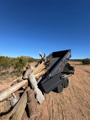 Hydraulic dump trailer used for roofing tear-offs and property cleanups across the Lubbock area.