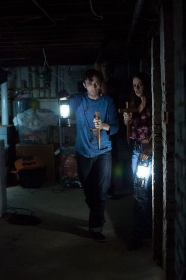 Anthony Misiano as Skip and Tia Link as Helena search the basement with lanterns