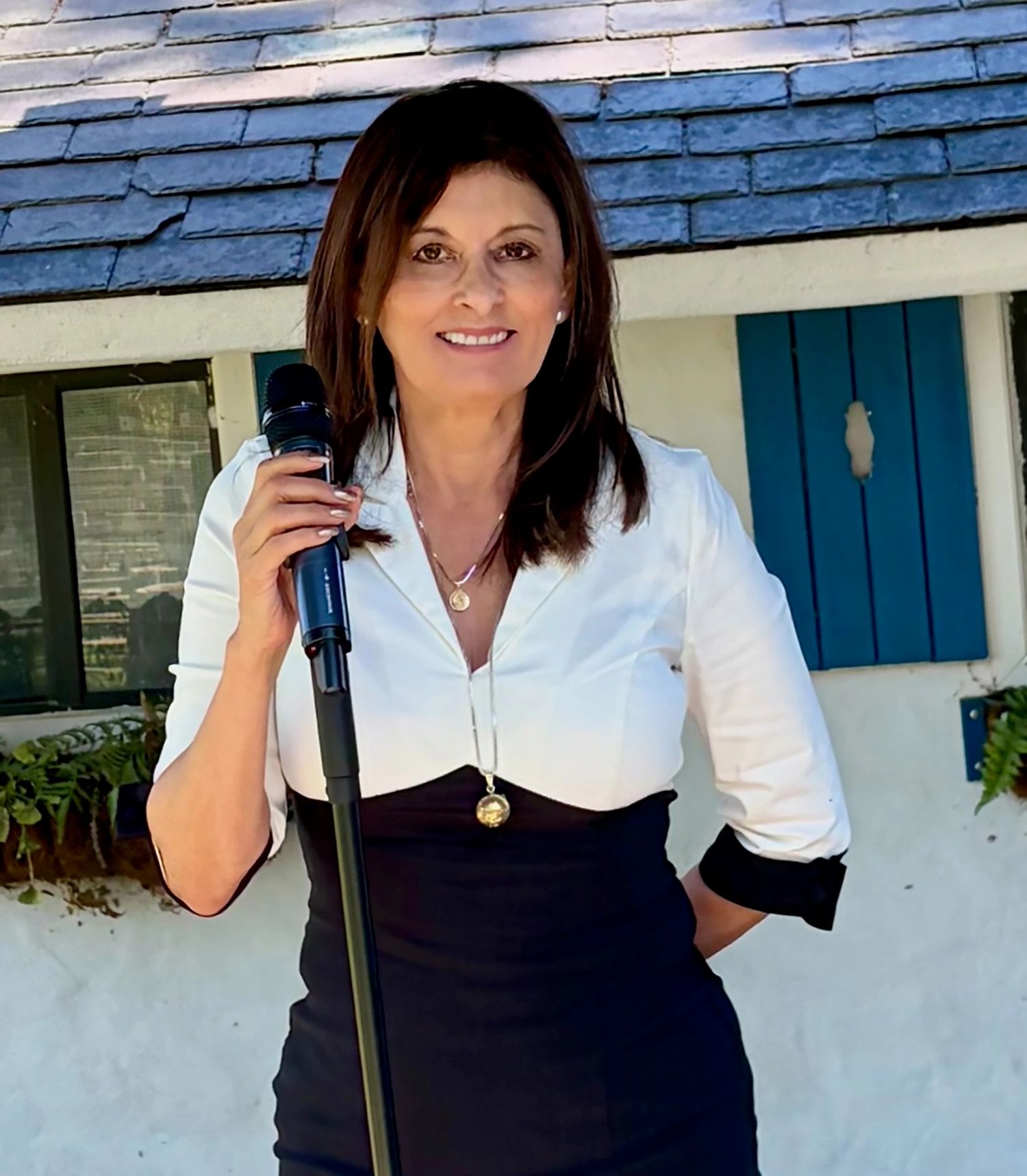 woman wedding officiant, wedding minister with microphone and black and white dress