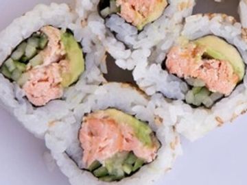 Sushi rolls with ginger and wasabi on a white plate.