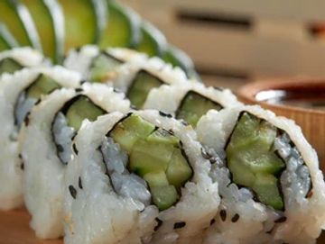 Fresh cucumber sushi rolls arranged neatly with chopsticks.