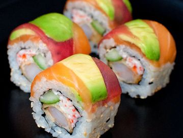 Colorful sushi rolls with avocado and fish.