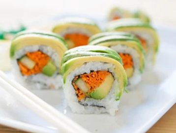 Fresh vegetable sushi rolls topped with avocado slices.