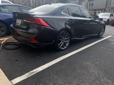 Black Lexus IS 350 parked in a lot near a building.