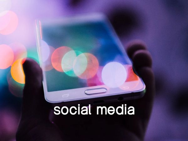 Impressionistic blurred lights as a backdrop to a hand holding a smartphone
