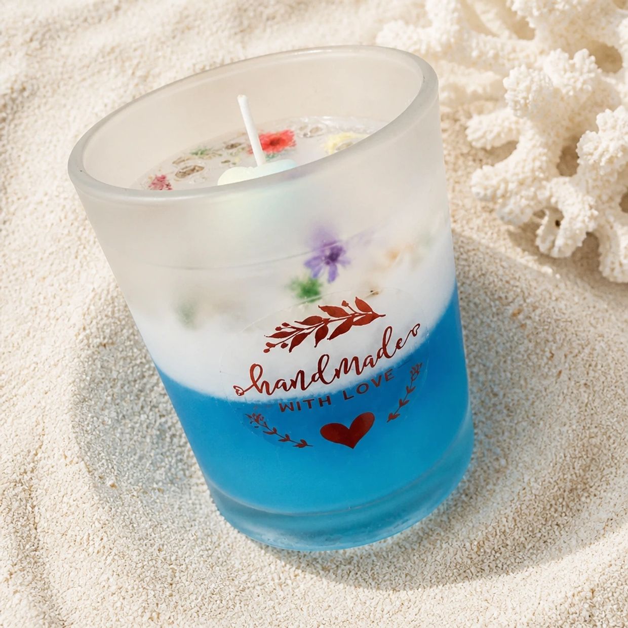 Handmade blue and white candle with floral decorations.
