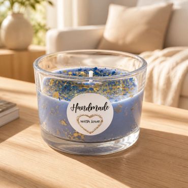 Blue handmade candle with gold flakes in a glass jar.