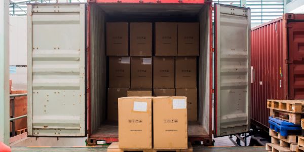 Shipping container filled with cardboard boxes.