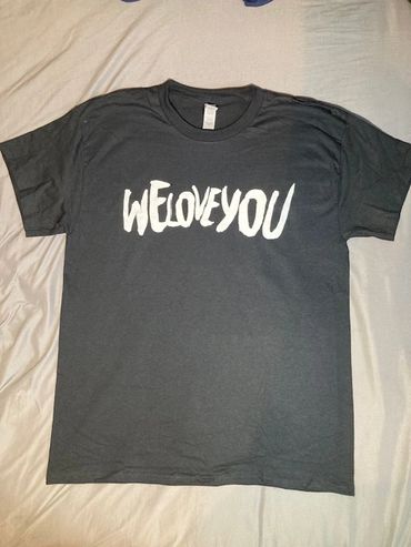 Black t-shirt with bold white text saying 'WE LOVE YOU'.