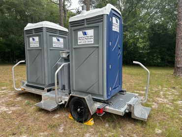 Dual porta potty trailer with steps and a handwashing station