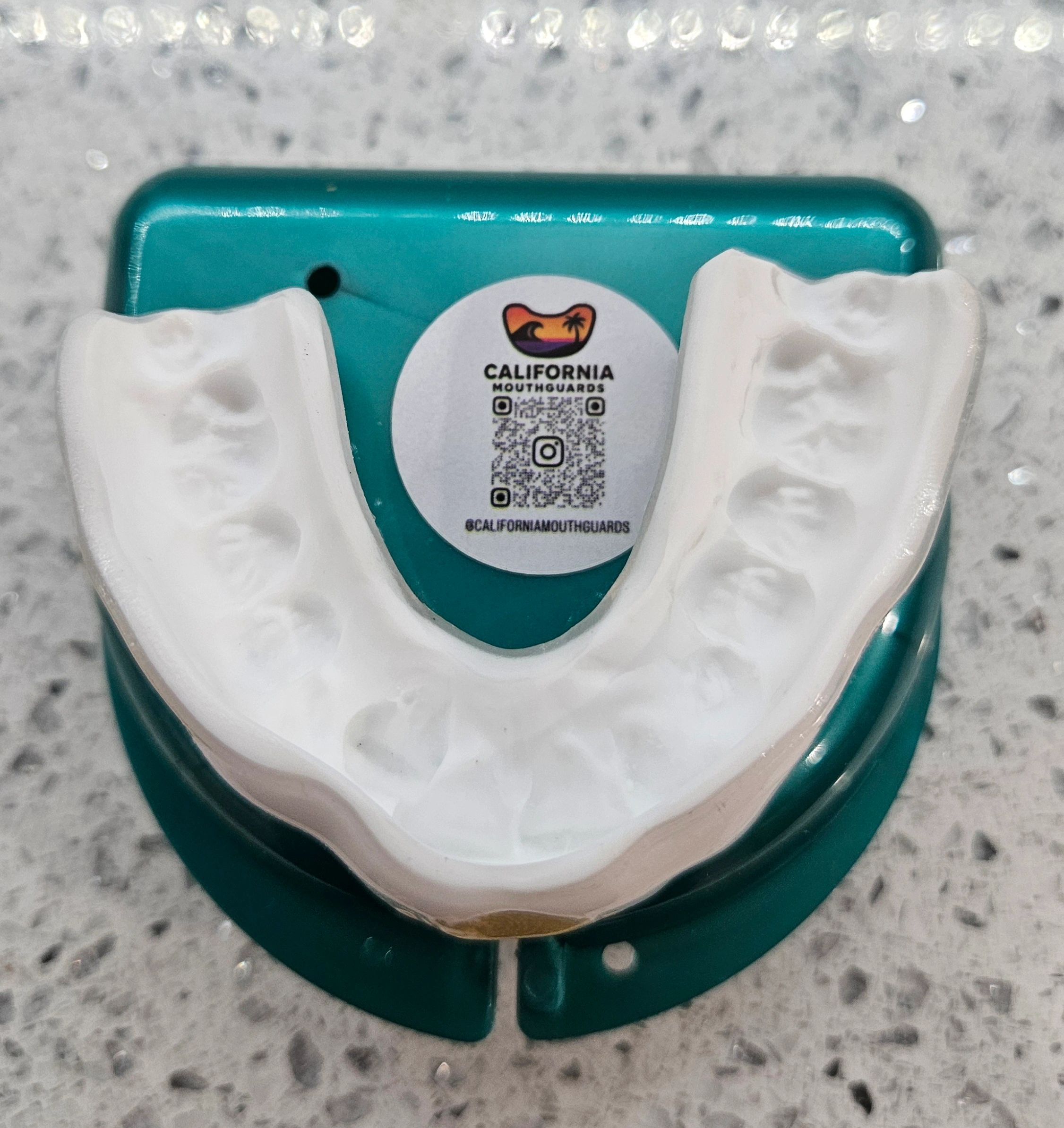Custom dental mouthguard mold on a teal case labeled California Mouthguards.